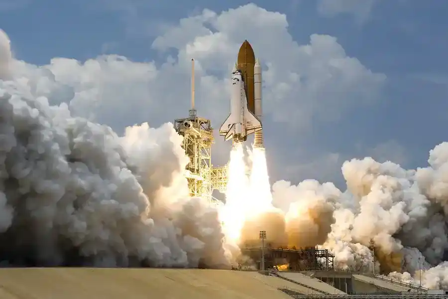 The launch of the rocket carries a space shuttle from its platform, leaving a large mass of fire and a lot of smoke and vapor